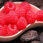 A saucer filled to the brim with red raspberries