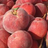 Ripe red fuzzy-skinned peaches in baskets.